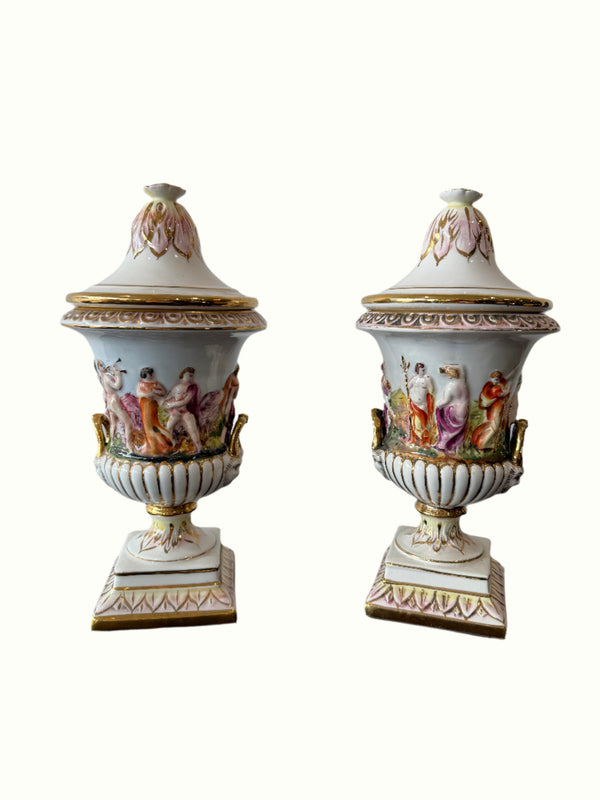 Two ornate ceramic urns with detailed designs 