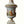 Decorative urn with intricate designs and figures on a plain background
