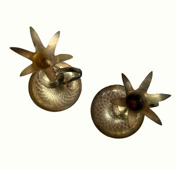Two brass candle holders with star-like designs 